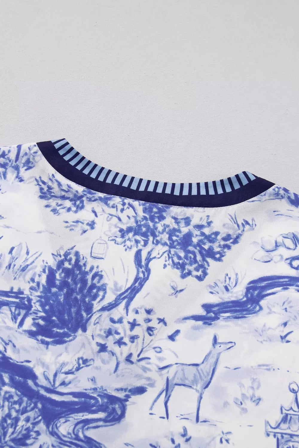 Blue toile print v-neck blouse with striped neckline detail