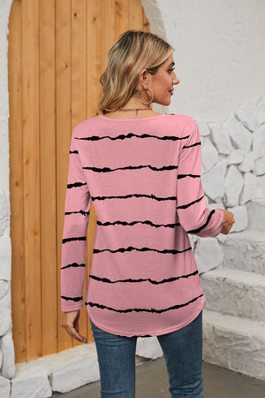 Carnation pink long sleeve blouse with black wavy stripes and curved hem.