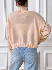 Blush pink cropped turtleneck sweater with ribbed trim and relaxed fit.
