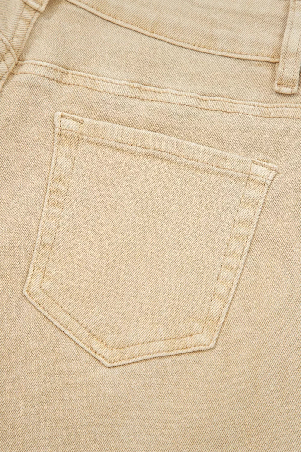 Beige denim jeans with a visible back pocket detail and contrast stitching.