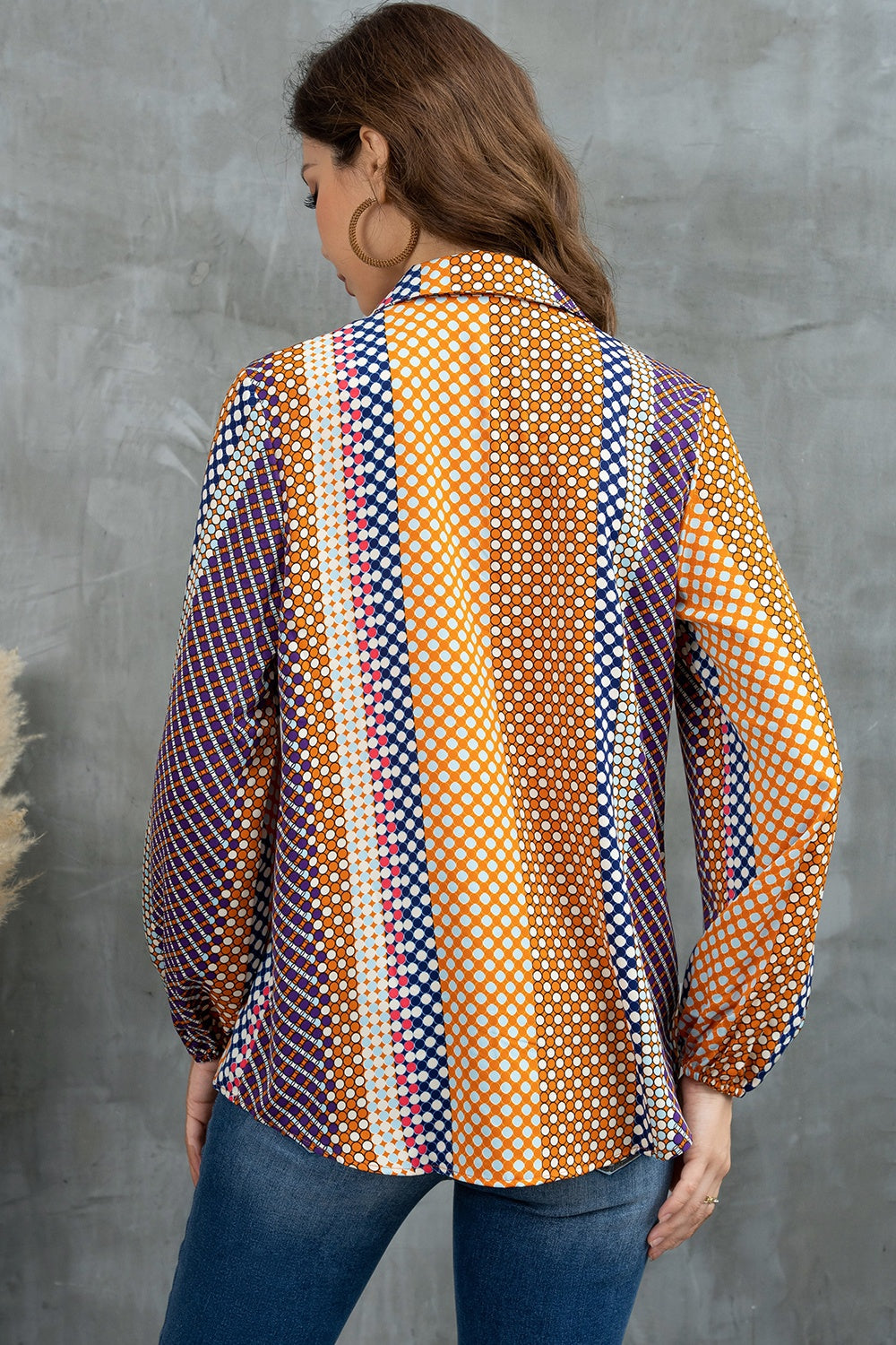 Blouse with geometric print, blouson sleeves, and a collared neckline in orange and blue.
