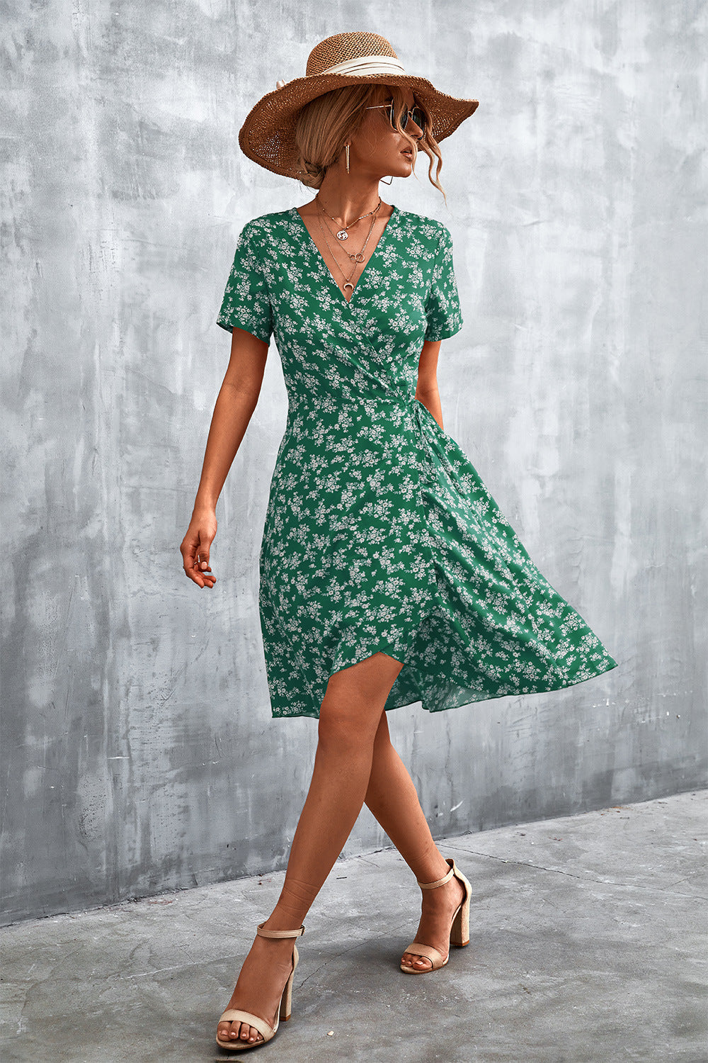 Light green floral wrap midi dress with short sleeves and v-neck, styled with a straw hat.