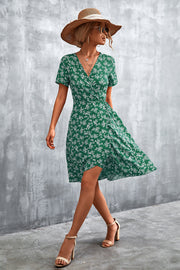 Light green floral wrap midi dress with short sleeves and v-neck, styled with a straw hat.
