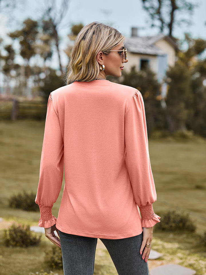 Peach long sleeve blouse with pleated yoke and shirred cuffs.