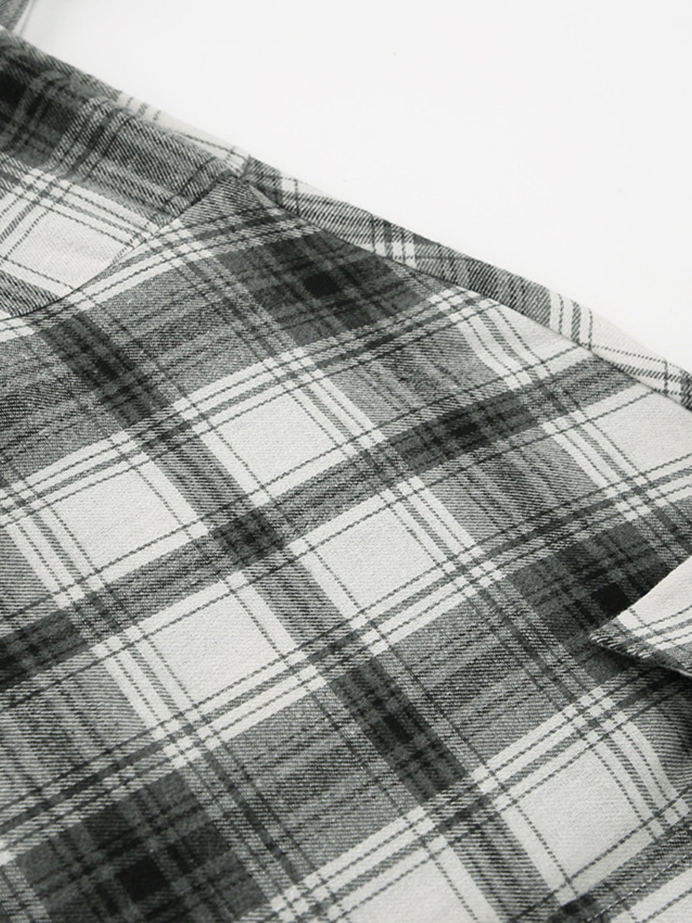 Button-up long sleeve shirt in black and white plaid cotton.