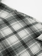 Button-up long sleeve shirt in black and white plaid cotton.