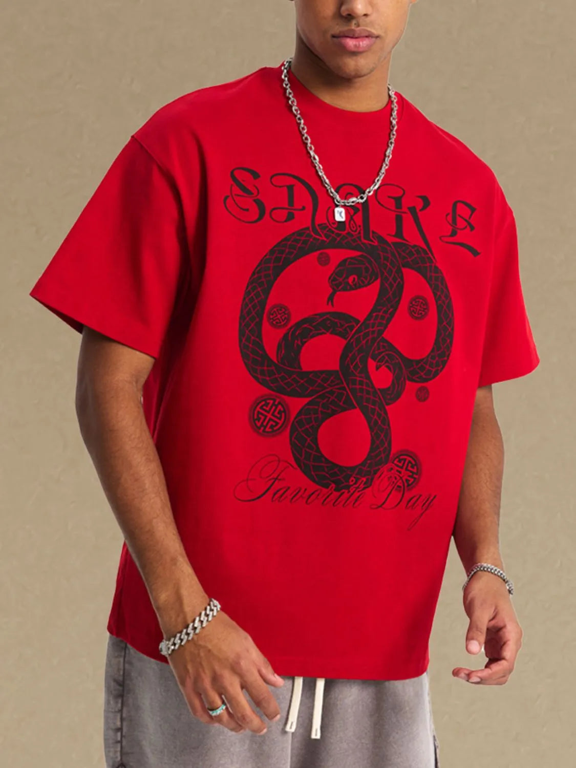 Red oversized t-shirt with black serpent graphic and text.