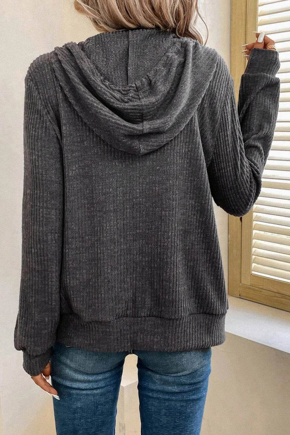 Dark gray textured ribbed knit hoodie with a relaxed fit and drawstring hood.