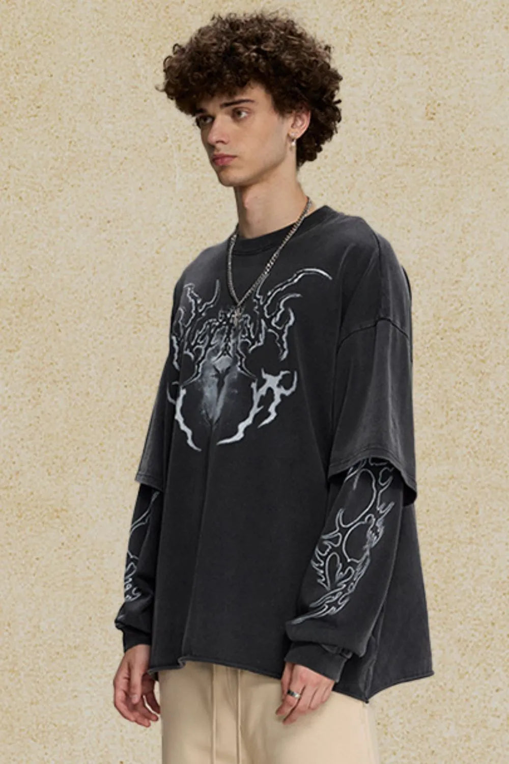 Black layered graphic sweatshirt with distressed details and bold white print on chest and sleeves.