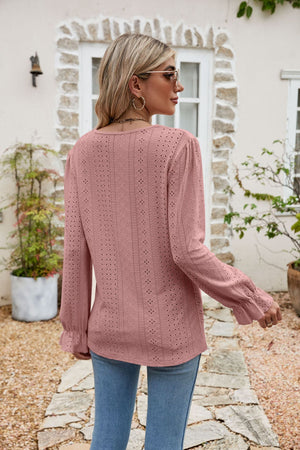 Blush pink eyelet lace blouse with ruffle sleeves and a textured pattern.