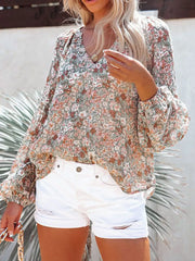 Floral print V-neck long sleeve maternity shirt with bishop sleeves and a green, pink, and white floral pattern.