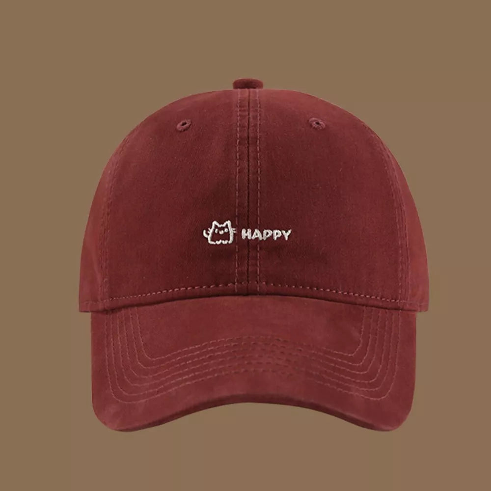Wine red cotton baseball hat with embroidered cat and happy text detail.
