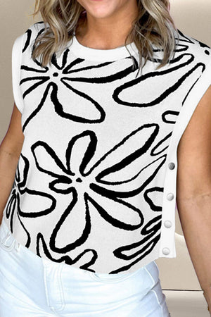 White knit top with black floral print and side button detail.