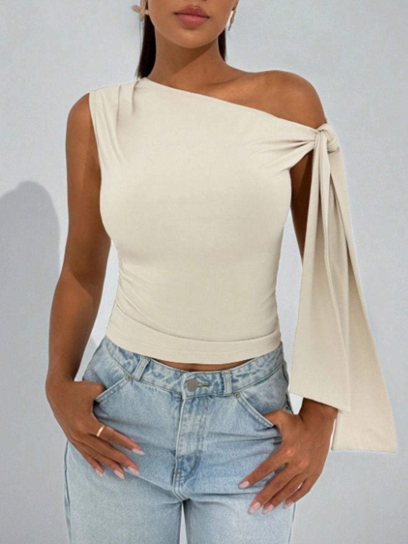 Apricot asymmetrical tie detail blouse with one-shoulder neckline and cropped length.