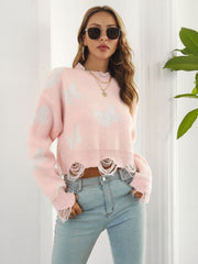 Blush pink cropped knit sweater with distressed hem and butterfly print.