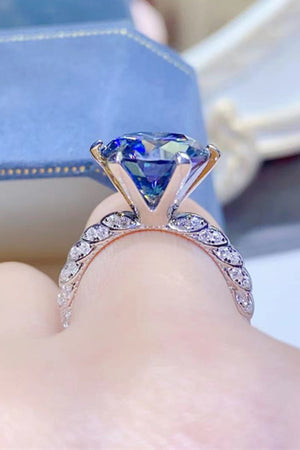 Midnight blue solitaire engagement ring with pavé diamond band.