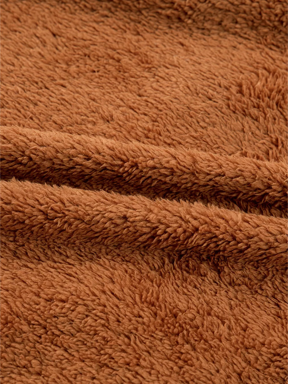 Cozy brown plush fabric texture detail of a zippered vest coat