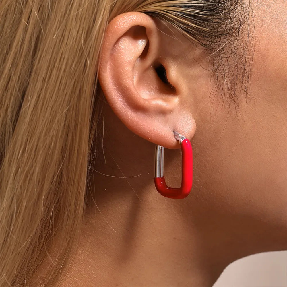 Red and silver two-tone enamel rectangle hoop earrings.