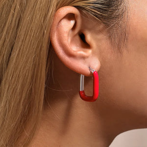 Red and silver two-tone enamel rectangle hoop earrings.