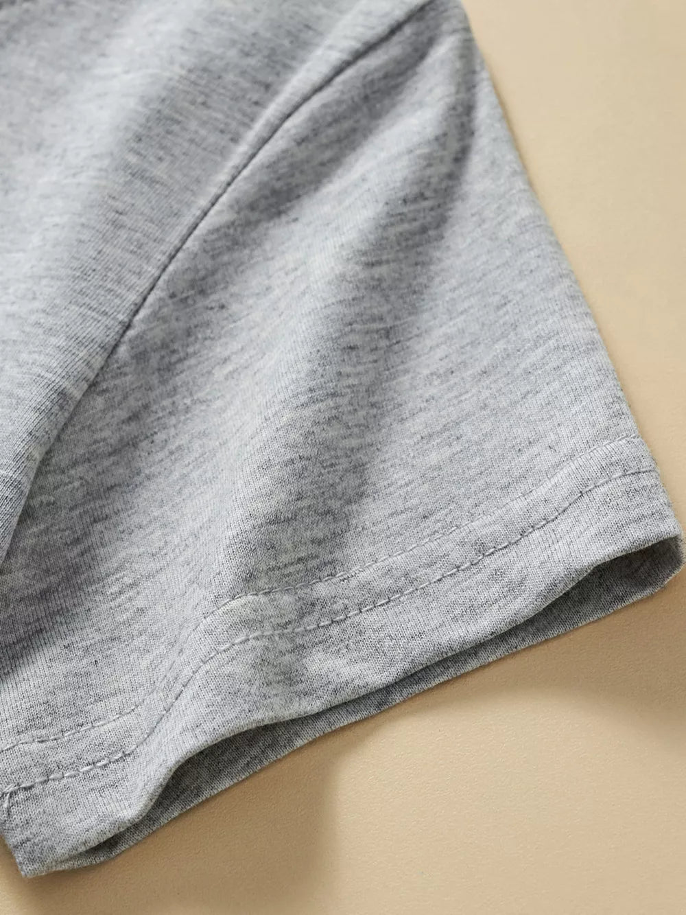 Grey cotton toddler t-shirt sleeve detail with double stitching.
