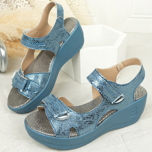Sky blue textured wedge sandals with adjustable straps and contrast stitching.