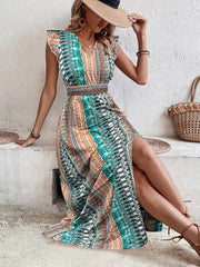 Bohemian maxi dress with ruffle sleeves, V-neck, smocked waist, and high slit in a colorful tribal print.