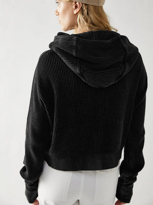 Black waffle knit cropped hoodie with hood and long sleeves.
