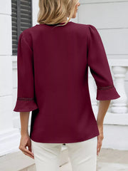 Wine red 3/4 sleeve blouse with lace trim on flared cuffs.