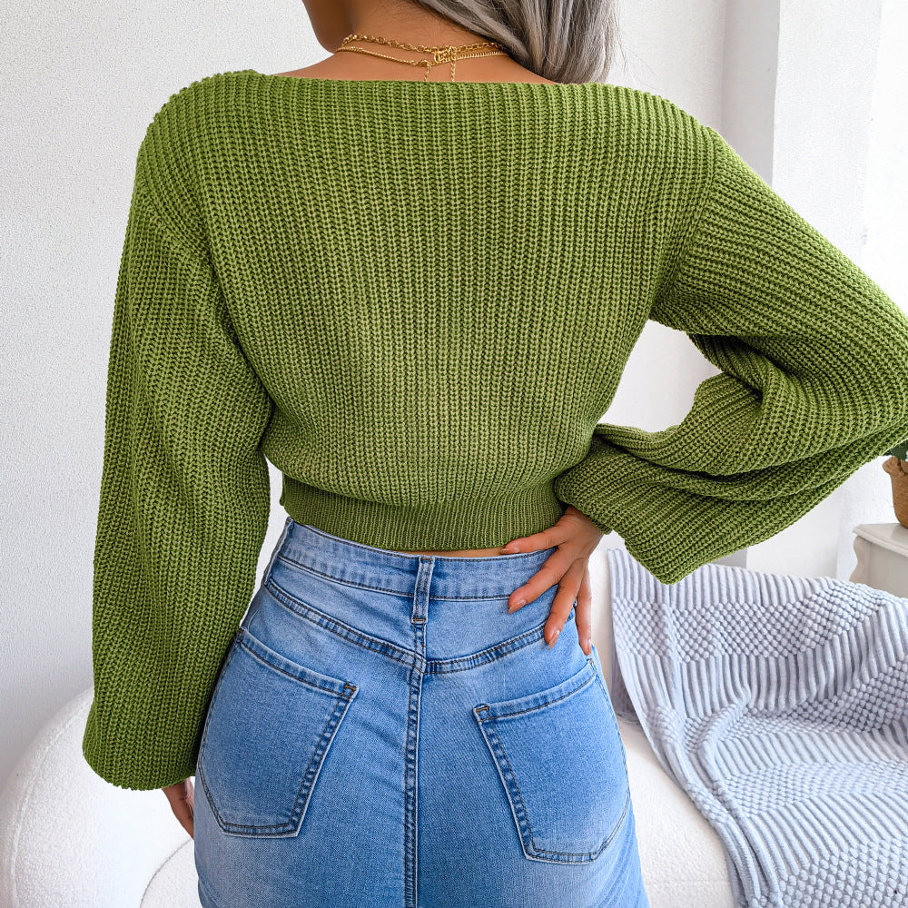 Green ribbed knit crop top with a boat neck and balloon sleeves, styled with denim.