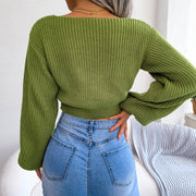Green ribbed knit crop top with a boat neck and balloon sleeves, styled with denim.