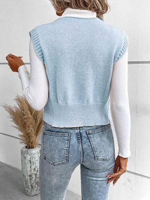 Light blue knit vest with ribbed trim and crew neck, worn over a white turtleneck.