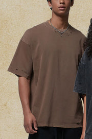 Distressed oversized cotton tee in coffee brown with raw hem and ripped details.