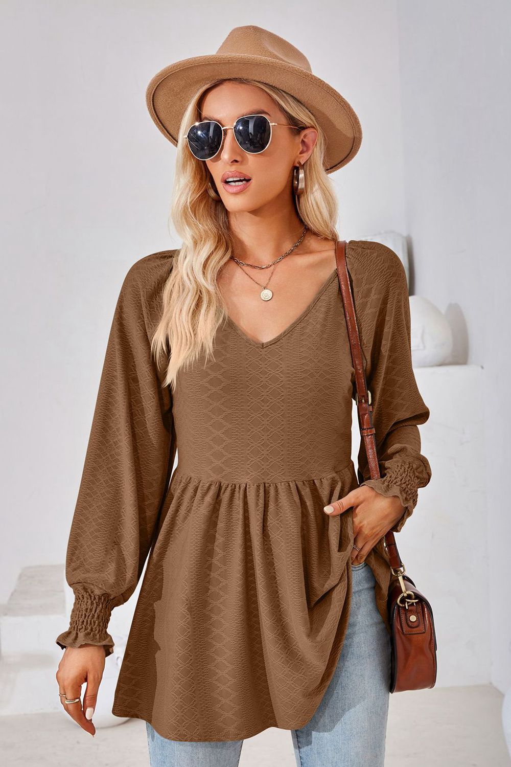 Brown textured babydoll blouse with V-neck and smocked cuffs