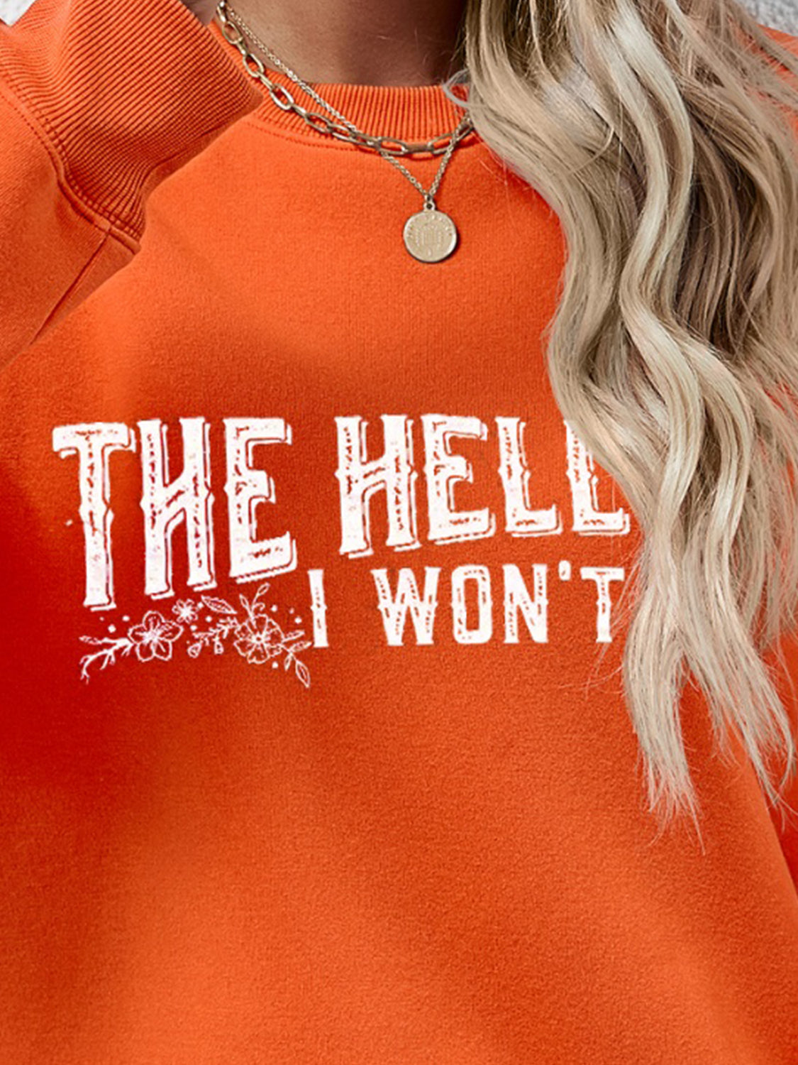 Graphic crewneck sweatshirt in Pumpkin with white text and floral detail.