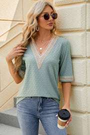 Light green textured V-neck blouse with lace trim on neckline and sleeves.