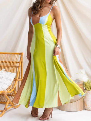 Vibrant color block maxi dress with spaghetti straps and high slits in yellow, blue, and brown hues.