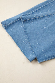 Blue denim jeans with distressed details and raw hem