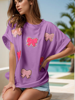Lavender oversized tee with multiple sequin bow embellishments.