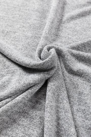 Dark gray slouchy knit top with button details, showing fabric texture.