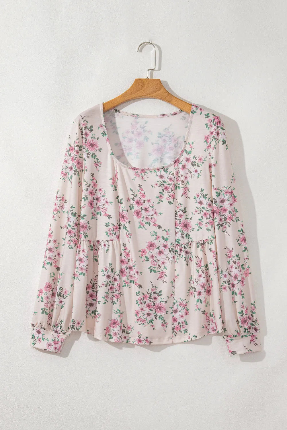 Floral print peplum blouse with square neck and long sleeves.
