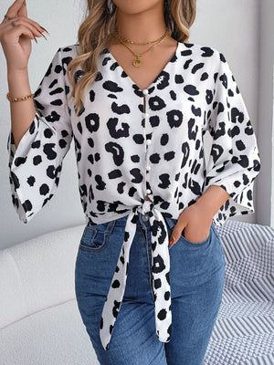 Leopard print tie-front blouse with button detail and bell sleeves.