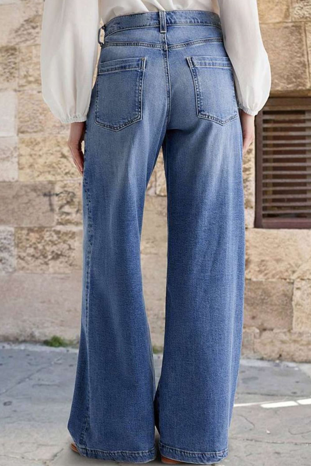 Light wash wide-leg denim jeans with subtle stitch detail and a buttoned fly.