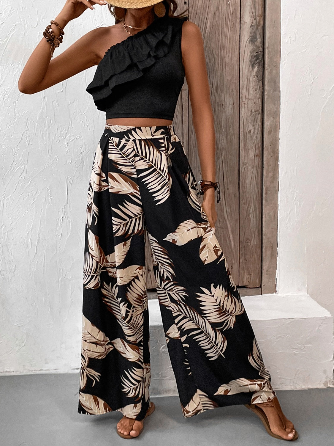 Black asymmetrical ruffle crop top with wide-leg palm print pants.
