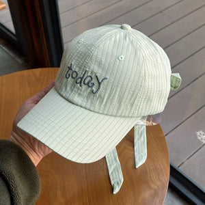 Pastel green cotton baseball cap with vertical stripes and embroidered "today" text.