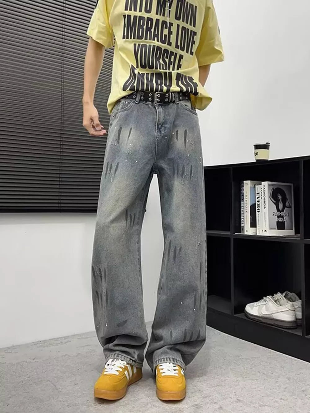 Men's wide-leg denim jeans in grey with distressed paint splatters and a relaxed fit.