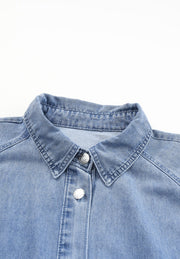 Light blue denim shirtdress with button front and collared neckline.