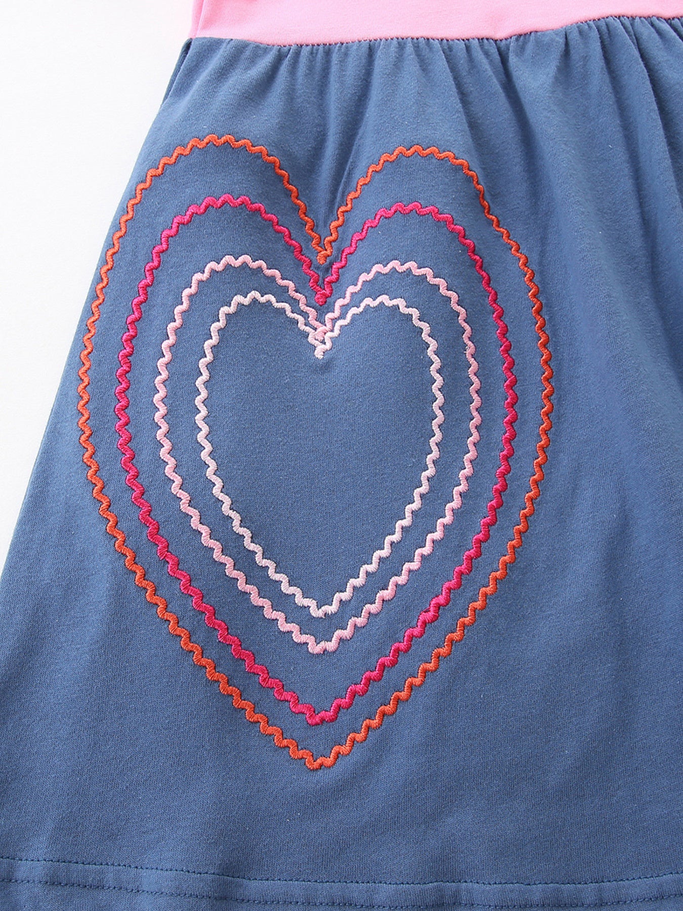 Blue toddler dress with embroidered hearts in pink, coral, and white stitching.