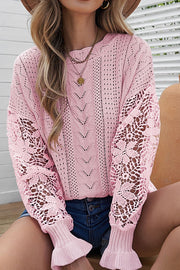 Pink openwork knit sweater with lace sleeves and ruffled cuffs.