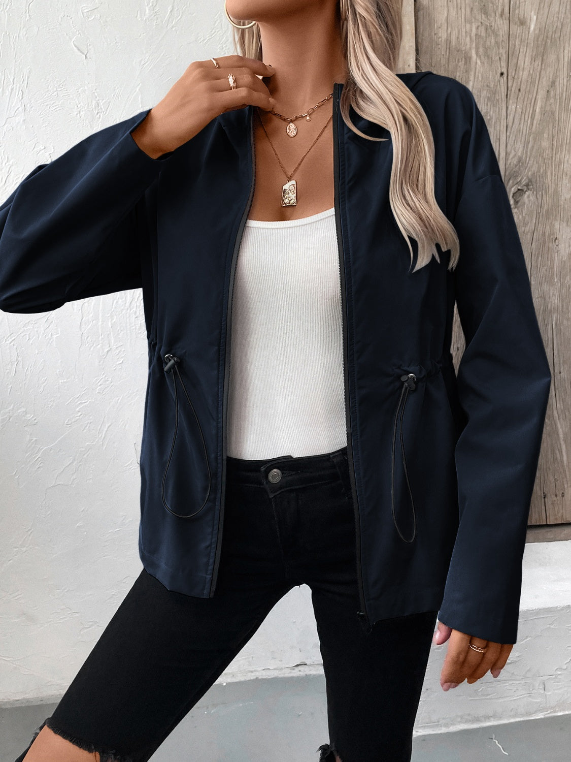 Navy cinched waist utility jacket with drawstring detail, zip front, and long sleeves.