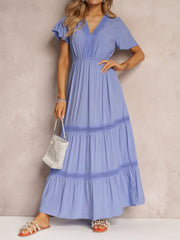 Blue lace-embellished tiered maxi dress with V-neck and flutter sleeves.